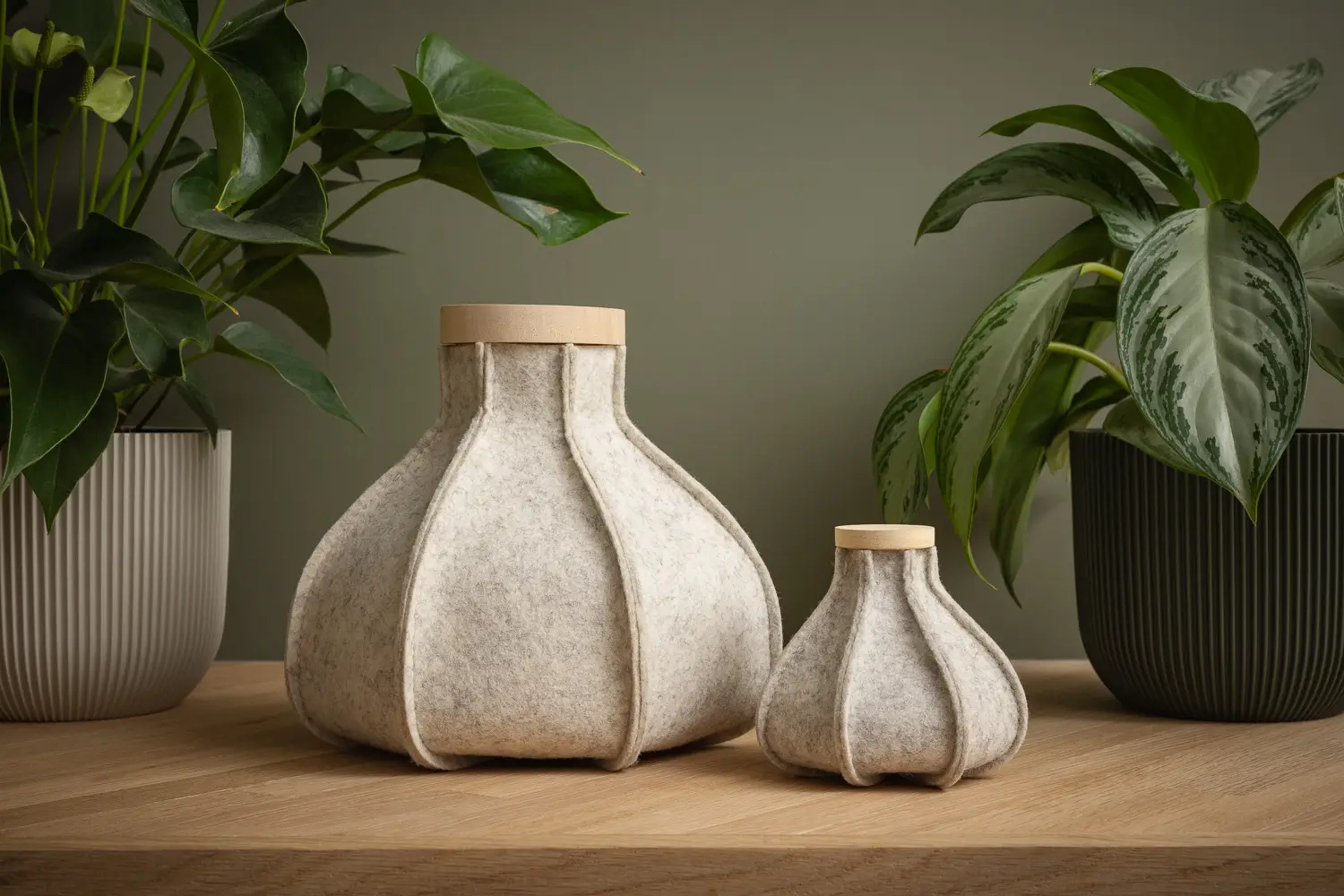 Urn met waxinelichtje op tafel naast een plantje