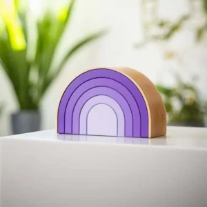 Wooden semicircular Rainbow urn in purple tones, placed on a white surface with plants in the background.