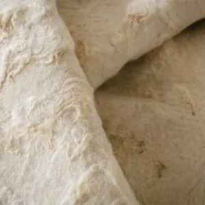 Close-up van een vouw in de witte gevilte wol met zachte wolkrullen