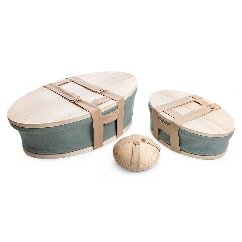 Het Heaven uitvaartmandje in twee maten in zachtgroen vilt met houten deksels en draagbanden, met daartussen een houten mini-urn
